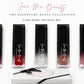 Five Face Me Beauty lip gloss tubes in a row on a white textured background, with three shades showing red-to-clear gradient glosses and two black tubes. A white box and black applicator are placed below the products.