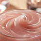 Jar of pink cream with a swirl on a blurred background